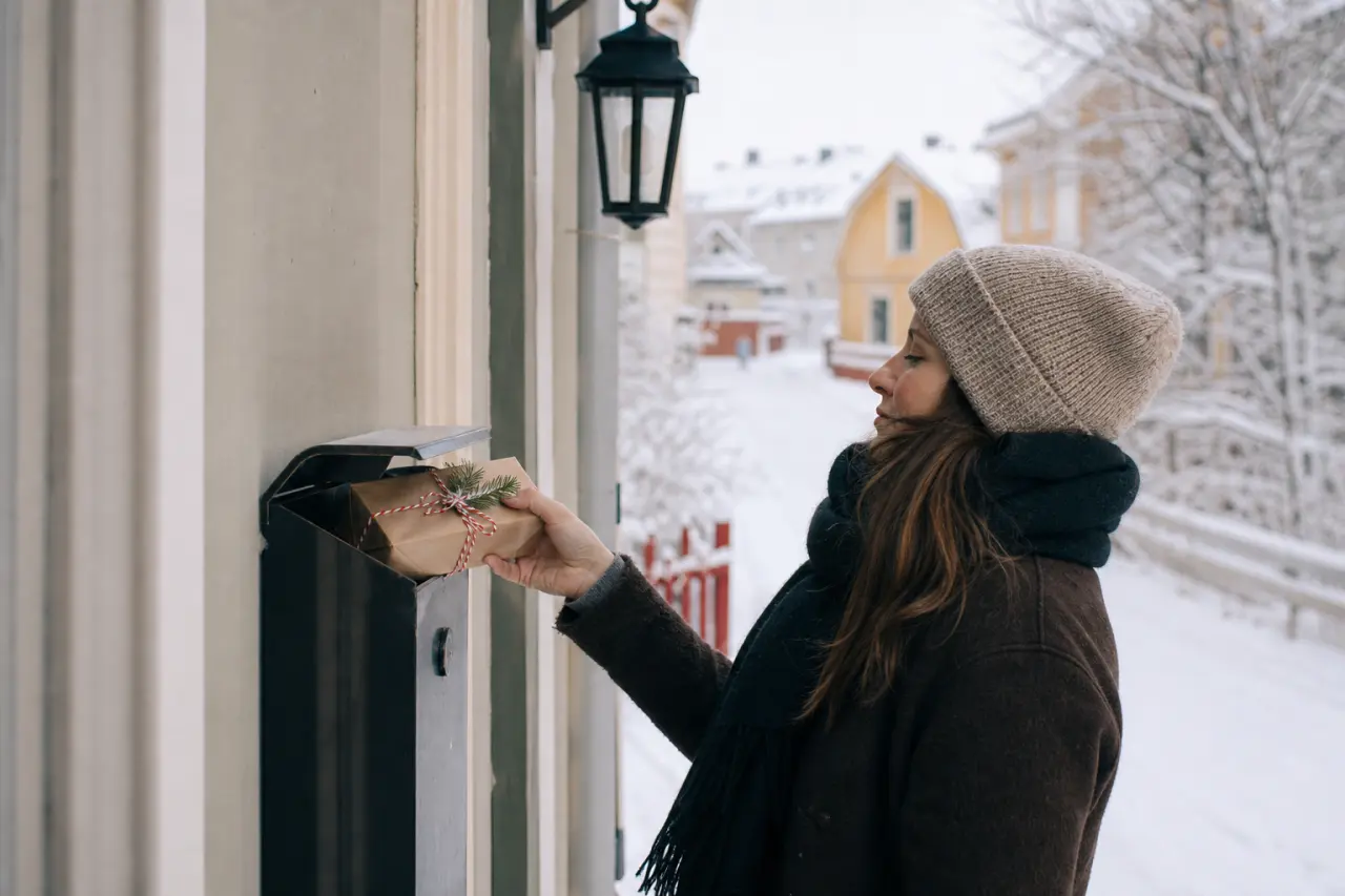 Liten inslagen present som läggs ner i en brevlåda