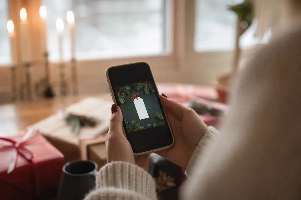 Mobiltelefon som visar ett digitalt presentkort med julmotiv